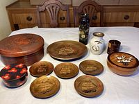 Full view of all items on a table including vases, lidded boxes, plates and the large wooden box.