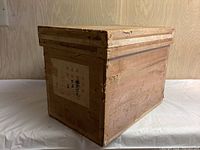 Photo of the wooden Japanese tea box exterior showing wood grain and label with Japanese characters.