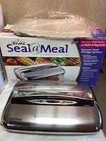 Rival Seal A Meal vacuum food sealer with box and extra vacuum food storage bags on top