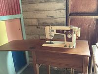 Wizard Citation sewing machine mounted in wooden table, measuring 23" W x 16" D x 31" H, shown in room corner.