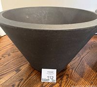 Side view of one brown planter showing tapered shape and textured rim