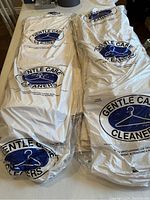 Two bundles of dry cleaned drapery panels wrapped in bags from Gentle Care Cleaners.