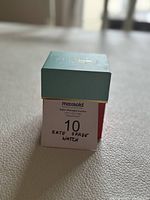 Original Kate Spade box lid showing turquoise top with gold foil logo