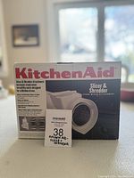 Front view of KitchenAid Slicer & Shredder Attachment box showing product image and branding.