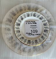Stack of the Minton plates showing the floral pattern and gold edge with a label indicating quantity and pattern name.