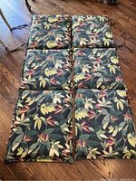 Top down photo of six sections of cushions showing the leaf pattern and tufting, placed on wood floor.