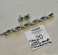 The full set of vintage Lisner bracelet and earrings displayed on white background with auction label.