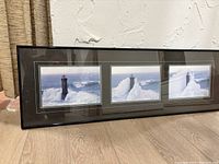 Framed triptych with three distinct lighthouse images surrounded by rough ocean waves.