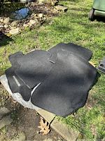 Multiple black carpet floor mats for Subaru vehicles placed outdoors on a surface.