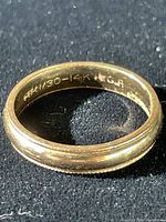 Close-up photo of the 14K gold band ring inside band marking 'HK 1/30 - 14K + G.P.' and visible surface wear.