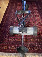 Full view of Lectronic Kaddy electric golf trolley showing its structural components, wheels, and push handle.