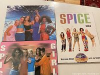 Photo showing three Spice Girls collectible posters mounted on board.