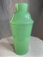 Front view of the jadeite Fenton vase showing its opaque green color and smooth glossy surface.
