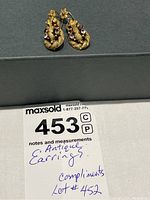 Full front view of both earrings on gray background with lot tag