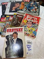 Photo showing collection including signed Walter Gretzky book, Life magazines with JFK and astronauts covers, comic books such as Born Again and Primal Man.