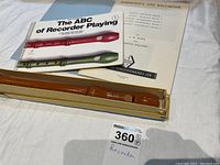 Wooden recorder in original box with two music books visible: The ABC of Recorder Playing and Harmonica and Recorder.
