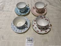 Four teacup and saucer sets arranged on table showing top view and pattern details
