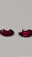 Close up of two marquis cut natural rubies side by side showing color, shape, and clarity.