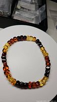 Top view of the Baltic amber bead bracelet showing color gradient beads arranged circularly on a white surface.