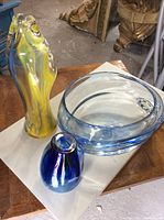 Photo showing all three items: yellow tall vase, small blue vase, and large blue bowl placed on a flat surface.