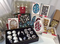 Photo showing multiple boxes and packages of Christmas ornaments in assorted colors and styles.