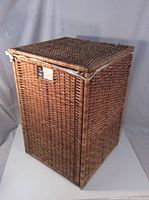Full view of rectangular reed wicker laundry hamper with lid closed