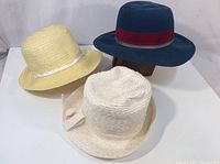 Lot of three vintage women's hats arranged together on a flat surface showing overall condition and variety.