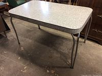 Photo of the full vintage expandable table showing the Arborite laminate top and chrome tubular legs.