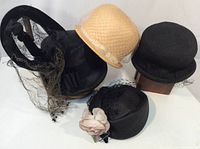 Group of five vintage women's hats showing variety of styles and colors.