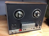 Front view showing two reel spindles, control knobs, switches, and tape transport unit with faded Realistic branding and 9998 model number