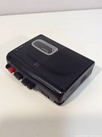 Front angled view of black Sony Walkman cassette player showing speaker grille, Sony logo, and cassette window.