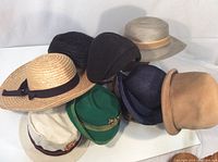 Photo showing eight different hats in various materials and colors, arranged to see details of each hat and their style variety.