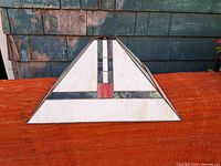 Front side view of the stained leaded glass lampshade showing white glass panels with green and black vertical and horizontal lines and a red square accent.