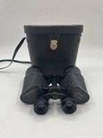 Overall view of binoculars in front of carrying case