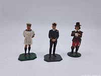 Front view of three hand-painted toy soldier figurines showing different historical military uniforms and bases.