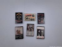 Photo displaying six vintage music cassette tapes laid out with front covers visible, including Guns N' Roses, Kiss, Grateful Dead, and others.