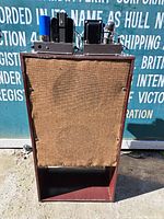Front view of the vintage speaker console with fabric grille covering the speaker area.