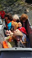 Photo of a bin containing 7 assorted vintage dolls including character dolls and soft-bodied dolls of different hair colors and clothing.