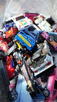 Pile of assorted small toy cars with visible paint and decal details.