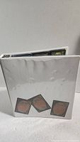 White Magic The Gathering binder showing card images and some wear