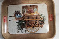 Full view of rectangular vintage Coca Cola serving tray showing picnic cart image, Coca Cola logos, and visible wear with scratches and dents.