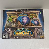 Photo of the unopened World of Warcraft Battle Chest box showing game art with multiple game titles and discs visible.