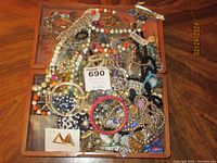 Top view showing a large assortment of broken and incomplete jewelry pieces in mixed styles and colors.