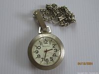 Westclox quartz pocket watch with silver-tone case and attached chain; white dial with black Arabic numerals and red seconds hand