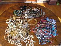 Wide shot of the entire collection of costume jewelry spread on wooden floor, showing the diversity in color and style.