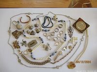 Photo showing entire assortment on a wood surface, includes rings, pins, necklaces, bracelets, and Tee Time Watch Key Holder with chain and medallion.