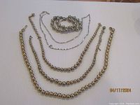 Full set of five Monet jewelry pieces including two gold-plated bead chokers, a two-strand silver ball bead bracelet, and two silver-tone necklaces.
