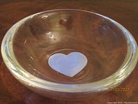 Clear crystal bowl showing the overall shape and embedded blue heart at the bottom center.