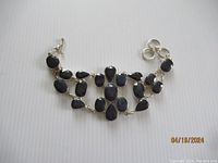 Full view of the sapphire bracelet laid flat showing the toggle clasp and extension rings.