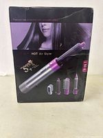 Front view of product box showing the 5 in 1 hot air styler and its five interchangeable attachments.